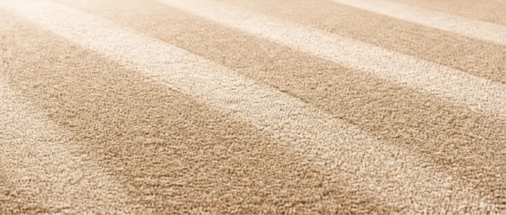 Beige carpet pile with diagonal light and dark shading bands running across it