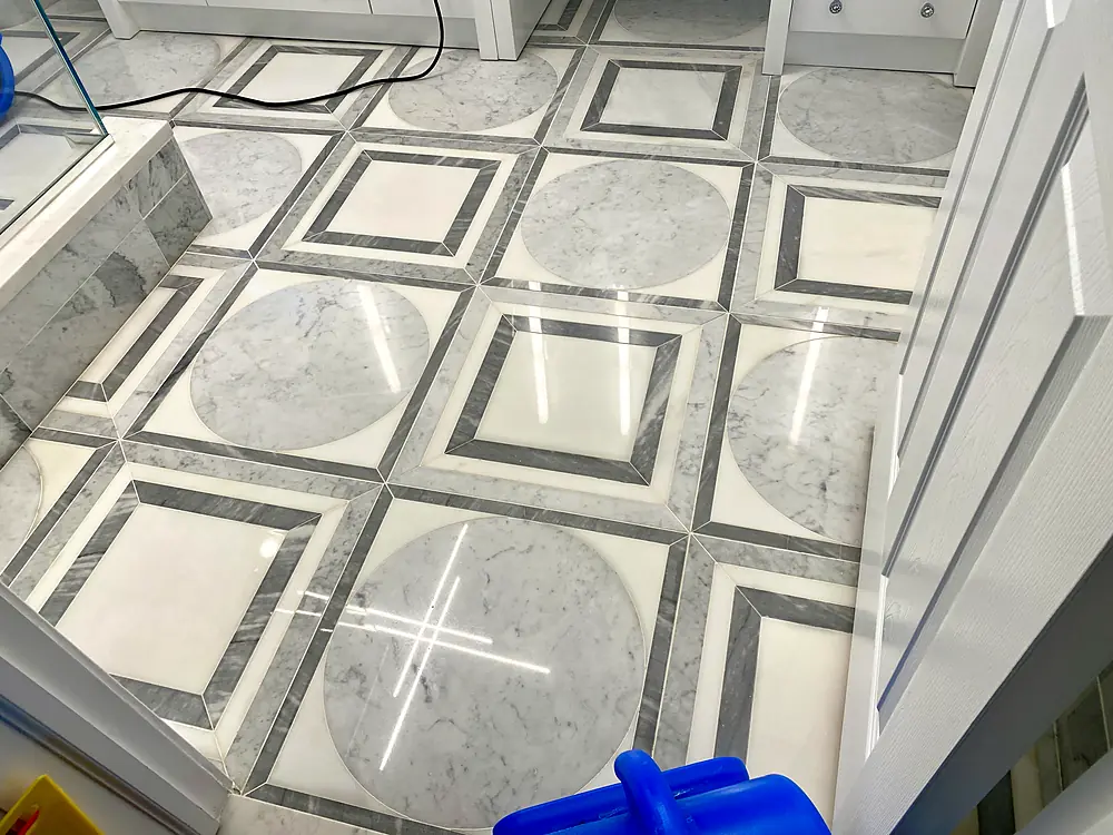Polished marble bathroom floor with a circle and square inlay pattern after natural stone cleaning in a Monmouth County, NJ home