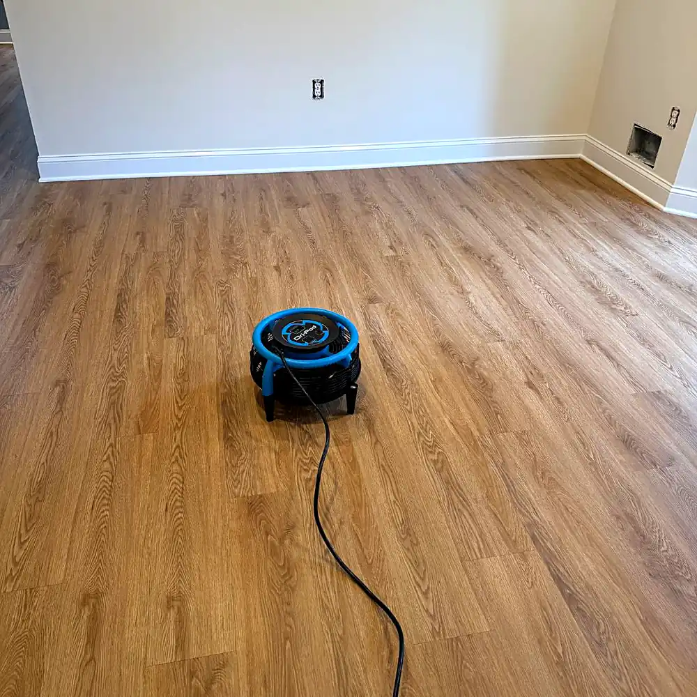 Air mover drying oak-look luxury vinyl plank flooring after laminate and vinyl floor cleaning in a Monmouth County, NJ home