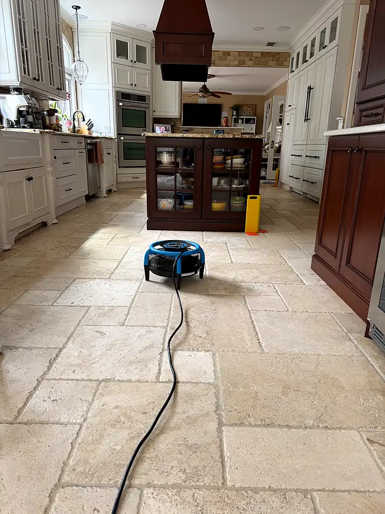 Kitchen with a travertine floor drying with an air mover after natural stone cleaning