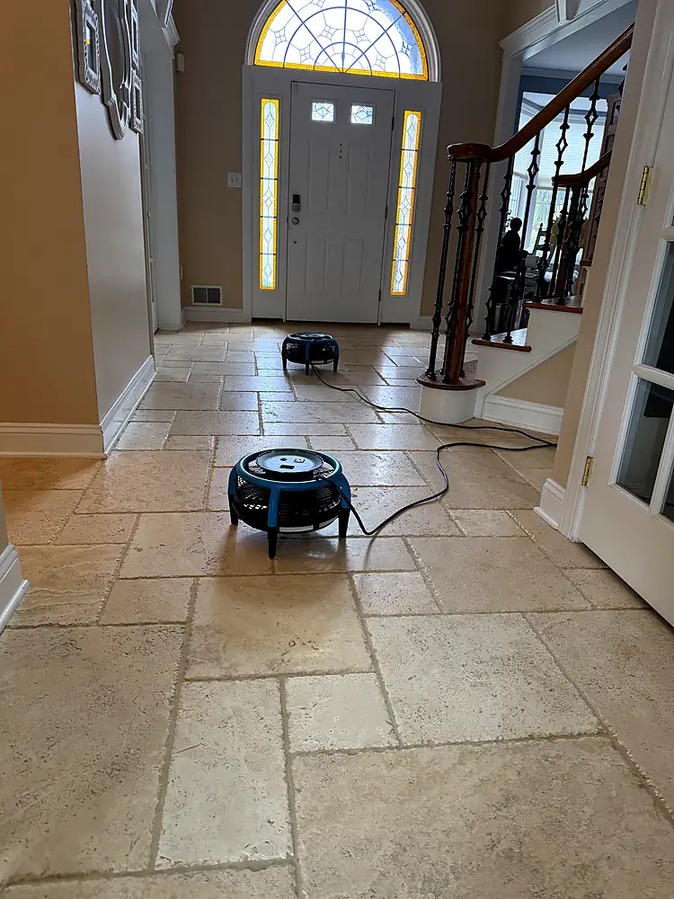 Travertine entryway tile drying with air movers after cleaning in a Monmouth County, NJ home