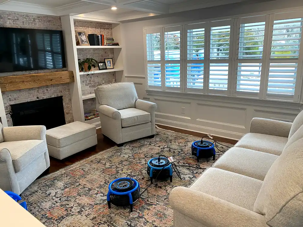 Armchairs and sofa drying with air movers after upholstery cleaning in a sitting room