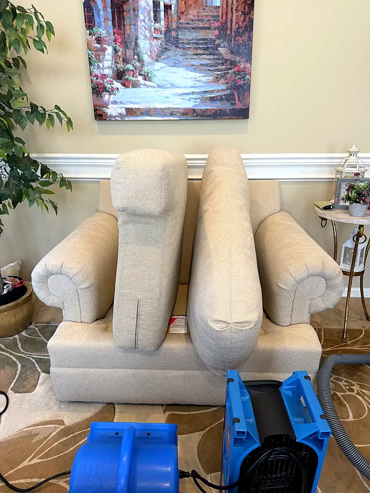Loveseat cushions propped to dry with air movers after upholstery cleaning